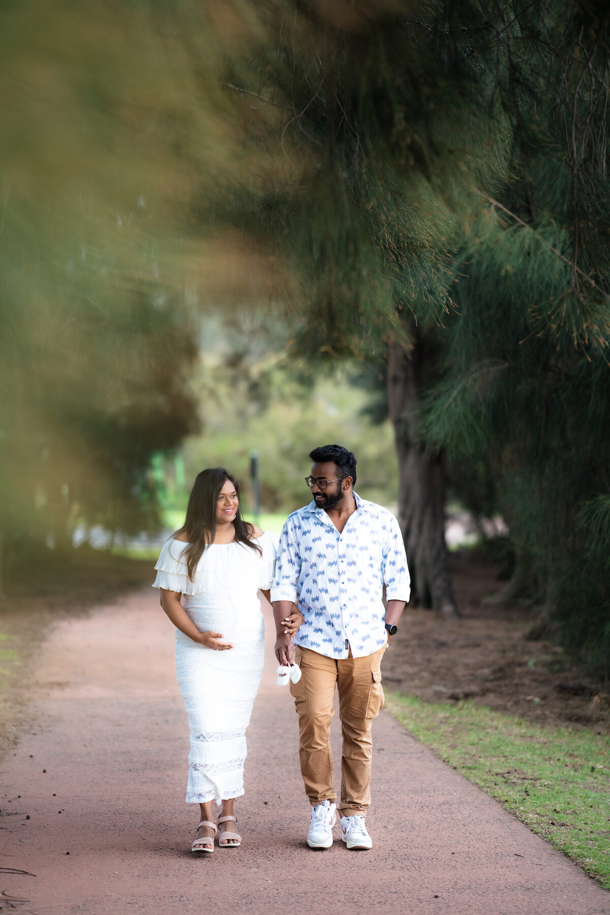 South Asian maternity couple walking on a path