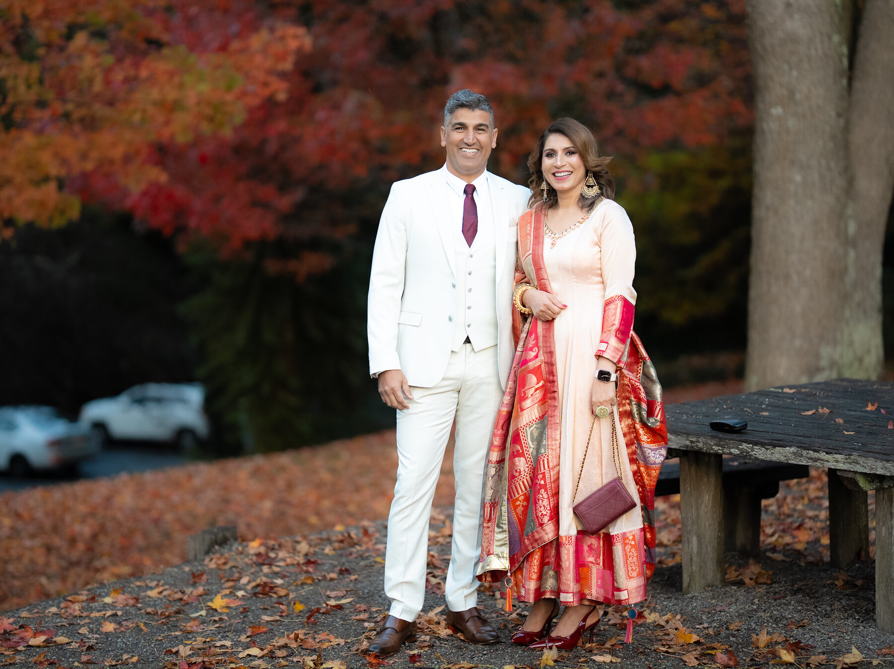 South Asian couple in front of an autumn maple tree